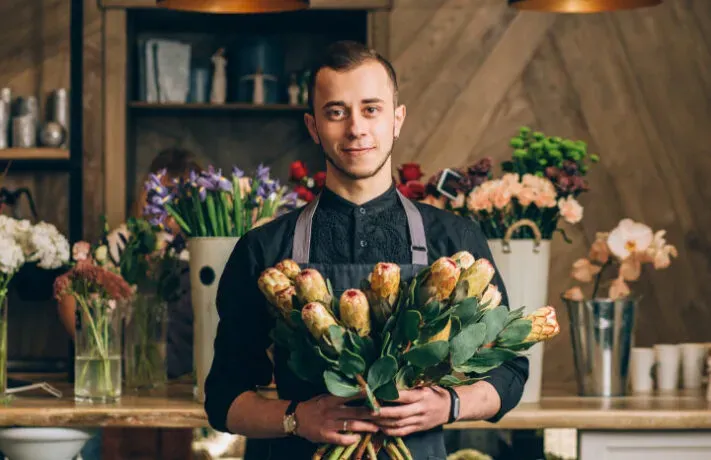 Un fleuriste présentant une composition florale